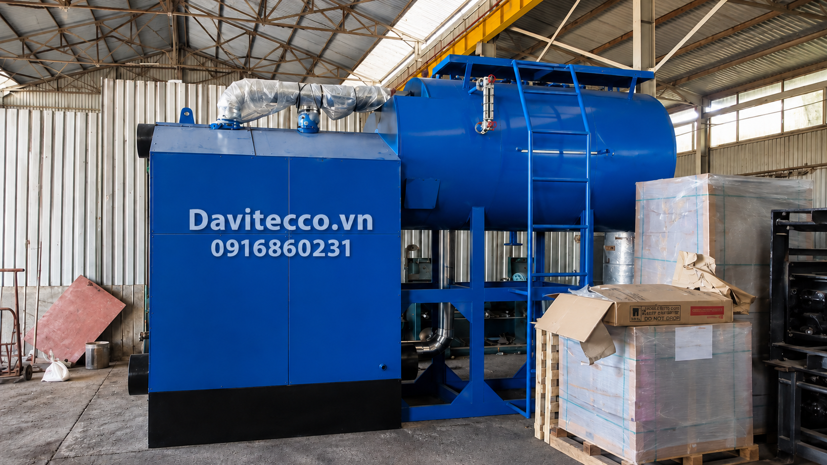 Lò hơi nằm ngang DAVITECCO màu xanh với thang tiếp cận, đường ống bọc cách nhiệt và cụm thiết bị phụ trợ trong xưởng