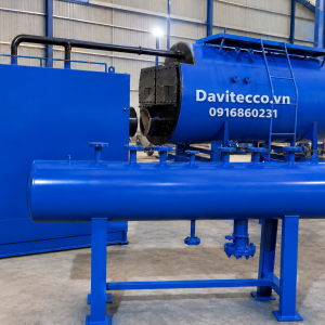 Lò hơi nằm ngang DAVITECCO màu xanh trong nhà xưởng, có cụm thiết bị phụ trợ, đường ống cách nhiệt và thang tiếp cận