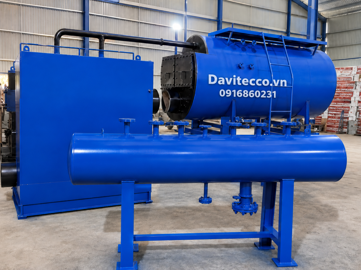 Lò hơi nằm ngang DAVITECCO màu xanh trong nhà xưởng, có cụm thiết bị phụ trợ, đường ống cách nhiệt và thang tiếp cận